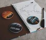 Flat lay of travel-themed accessories including a map, journal, and pins promoting exploration.